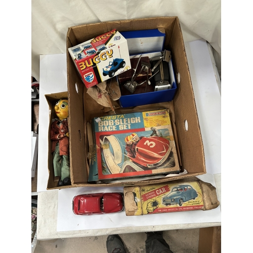 178 - A vintage boxed Chad Valley car, a vintage bisque headed doll (a.f) a Pelham puppet, bob-sled game e... 