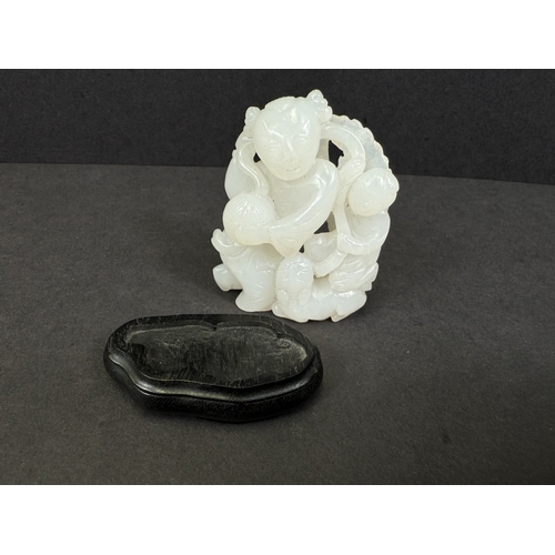 540G - An intricately carved and pierced Chinese white jade figure with child and dog, 64gm, ht 6cm, on woo... 