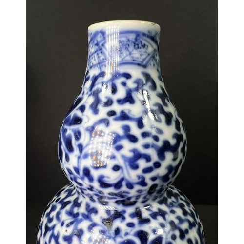 554 - A Chinese porcelain double gourd vase, 19th century, underglaze blue decoration, 13cm; another vase ... 