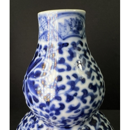 554 - A Chinese porcelain double gourd vase, 19th century, underglaze blue decoration, 13cm; another vase ... 