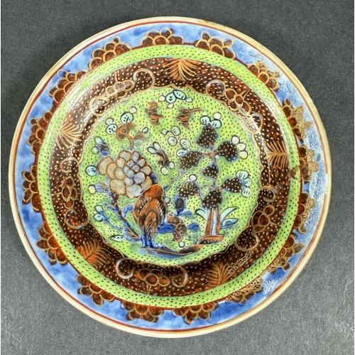 560D - A small 18th century Chinese 'Clobbered' dish, the central design with bird, flowers and trees on gr... 