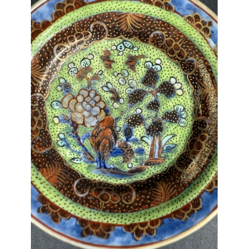 560D - A small 18th century Chinese 'Clobbered' dish, the central design with bird, flowers and trees on gr... 