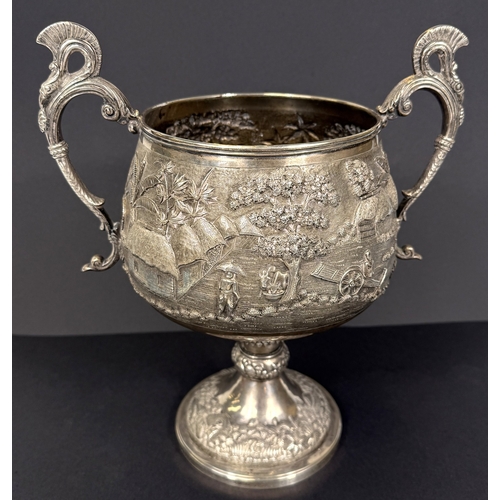 601 - A large late 19th century Indian white metal two-handled pedestal trophy cup with extensive relief d... 