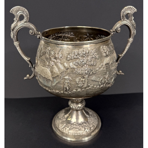 601 - A large late 19th century Indian white metal two-handled pedestal trophy cup with extensive relief d... 