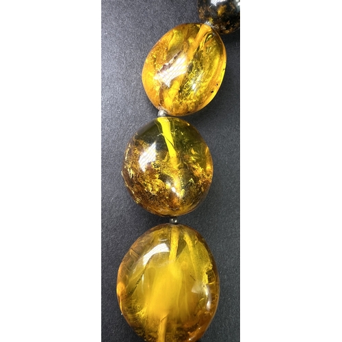 632 - A necklace formed from large graduating amber beads in a range of colours, weight 93gm, length overa... 
