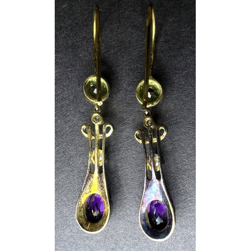 635 - A pair of Art Nouveau yellow metal earrings to match lot 634, set circular peridot with drop having ... 