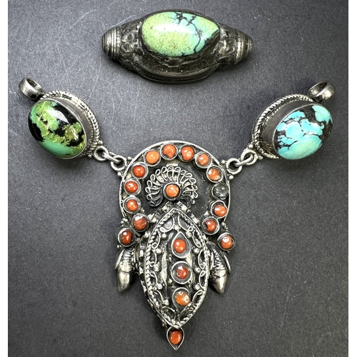 637 - An Eastern white metal pendant set with coral coloured stones, drops etc and a similar bead