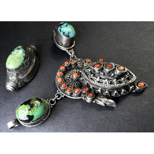 637 - An Eastern white metal pendant set with coral coloured stones, drops etc and a similar bead