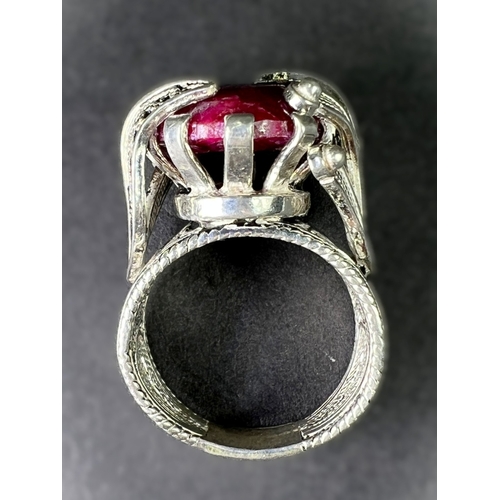 641 - A white metal dress ring set with large natural cut ruby stone in elaborate setting stamped 925