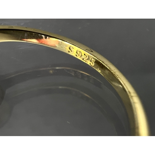 689 - A modern dress ring with 3 large moissanite stones (approx. 4ct total) in gold plated setting stampe... 