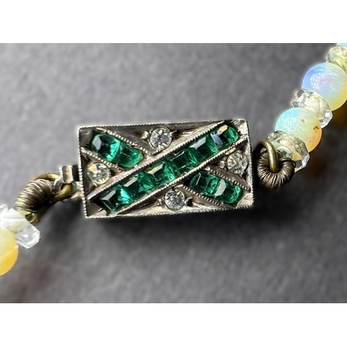 694 - An opal and crystal necklace formed fom a row of round opal beads spaced by faceted crystal rondelle... 