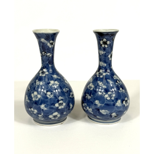 549 - A pair of oriental porcelain baluster vases decorated in underglaze blue with prunus blossom on crac... 