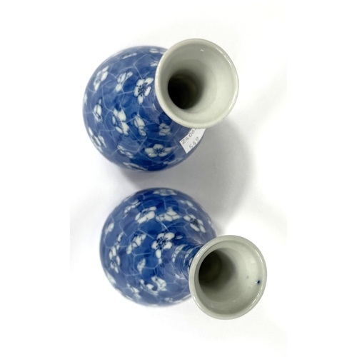 549 - A pair of oriental porcelain baluster vases decorated in underglaze blue with prunus blossom on crac... 