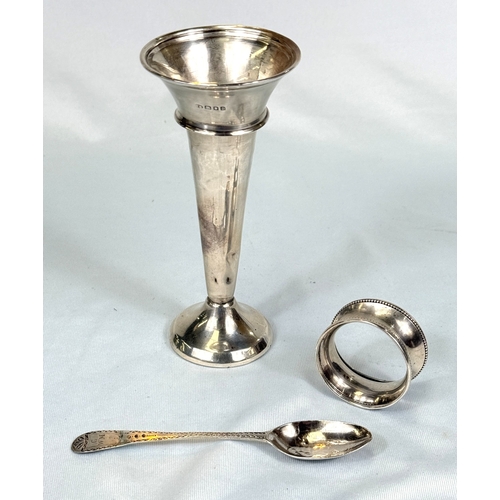 605 - A hallmarked silver posy vase with weighted base, two napkin rings and a teaspoon.