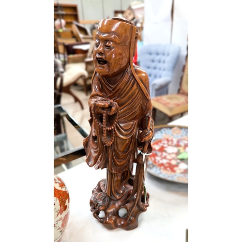 542 - A Chinese 19th century carved hardwood figure of a mendicant, 37cm