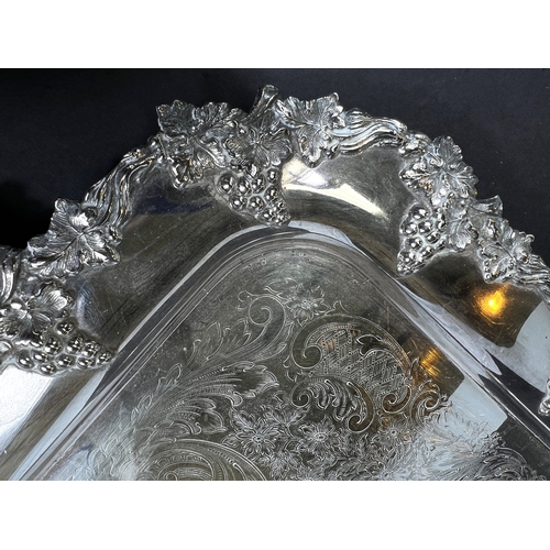614 - A large silver plated tray with grapevine border and double handles, 64cm