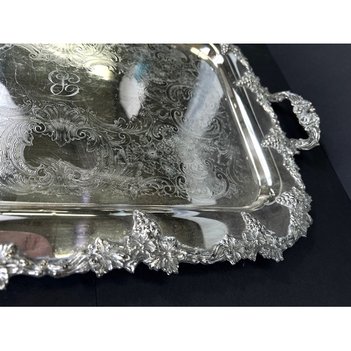 614 - A large silver plated tray with grapevine border and double handles, 64cm