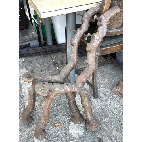 186 - A pair of naturalistic cast iron bench ends.