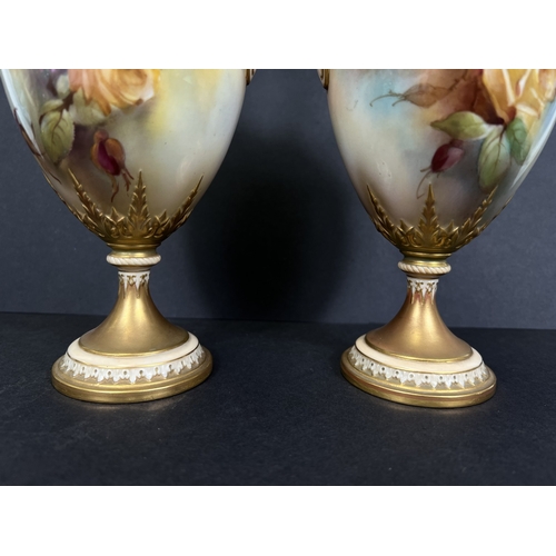 529 - Royal Worcester, a pair of hand painted vases, ovoid with double handles and pedestal, roses on ivor... 