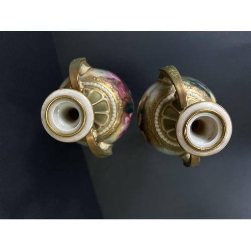 529 - Royal Worcester, a pair of hand painted vases, ovoid with double handles and pedestal, roses on ivor... 