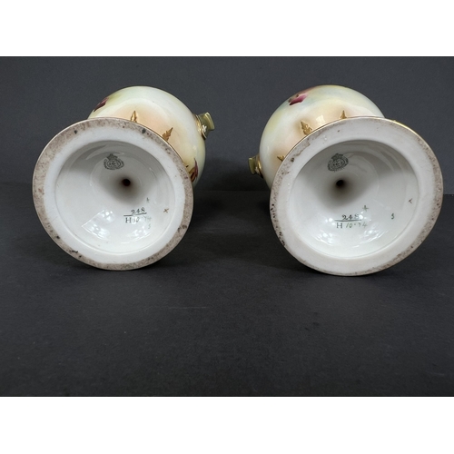 529 - Royal Worcester, a pair of hand painted vases, ovoid with double handles and pedestal, roses on ivor... 