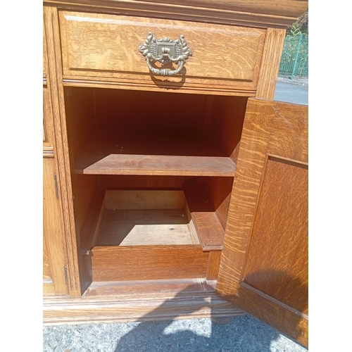 817 - A large golden oak Scottish sideboard with carved panel doors, four drawers and 3 cupboards.