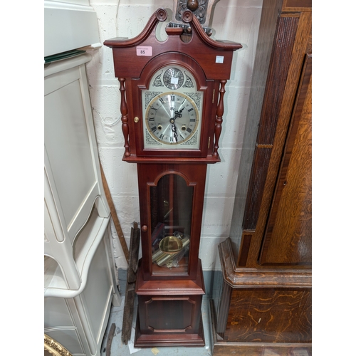 85 - A reproduction mahogany chiming grandmother clock.