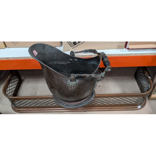 83 - A 19th century copper coal helmet and a pierced brass fender, length 97cm.