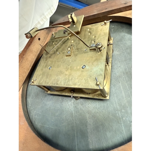 84 - A mid 20th century walnut table top radio with record player; a mahogany circular wall clock.