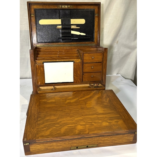 1 - An oak fall front writing box with fitted interior and a brass trivet....