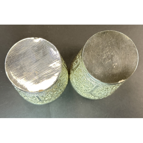 763 - A matched pair of early 20th century Indian white metal beakers with scrolling decoration 12.7oz.