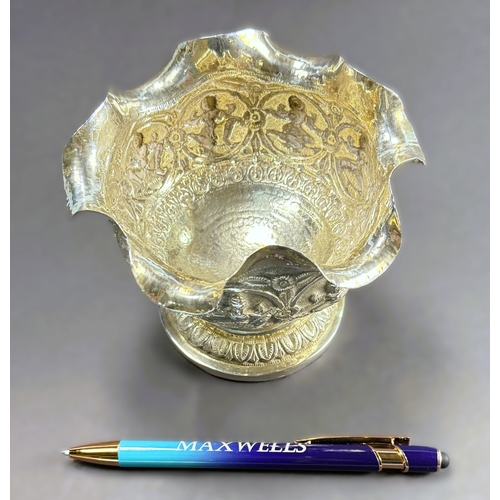 764 - An early 20th century Indian white metal pedestal bowl with wavy rim, embossed figural decoration, 4... 