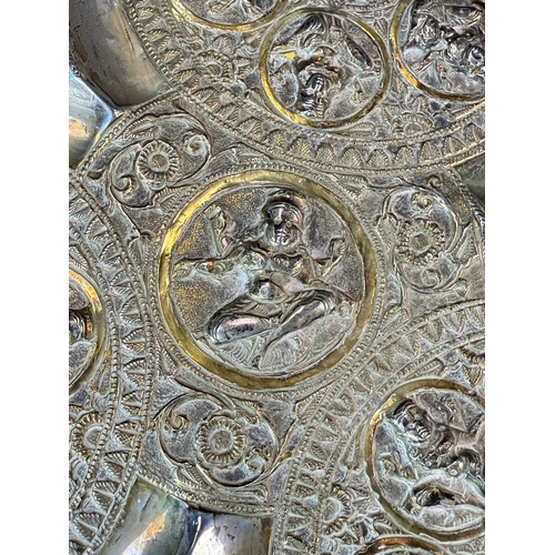765 - An early 20th century Indian silver lobed dish with deities in relief, 7.3oz