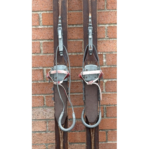 30 - A pair of vintage wooden skis in the manner of Lillywhites Sporting goods, with boot clips.