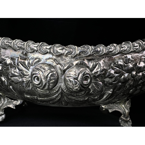 534 - A continental boat shaped 2 handled bowl with extensive embossed flowerhead and acanthus decoration,... 