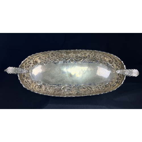 534 - A continental boat shaped 2 handled bowl with extensive embossed flowerhead and acanthus decoration,... 