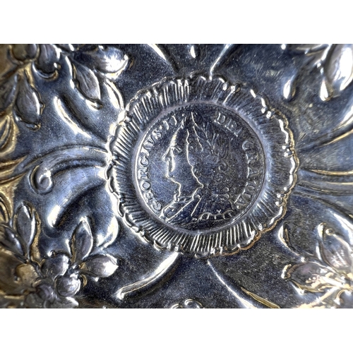 552 - An 18th century punch ladle with inset George II coin, with embossed decoration and twisted bone han... 