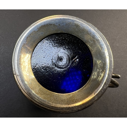 557 - A circular monogrammed mustard pot with blue glass liner, London 1898; a chased hallmarked silver ve... 