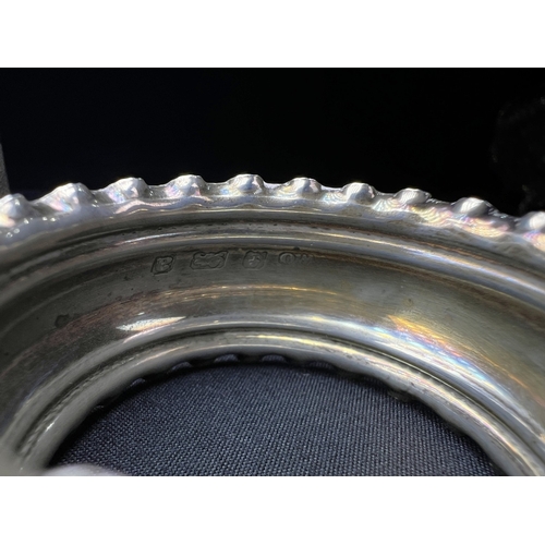 613 - A pair of chased hallmarked silver napkin rings; an engine turned pair of napkin rings; a hms salt o... 