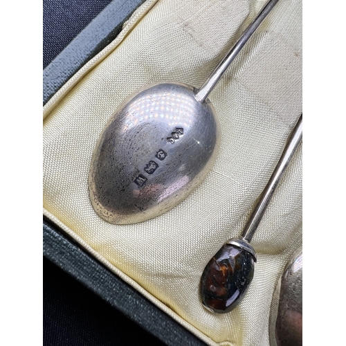 617 - A cased set of 6 hallmarked silver teaspoons by Liberty, Birmingham 1921, with amethyst 'bean knops'... 