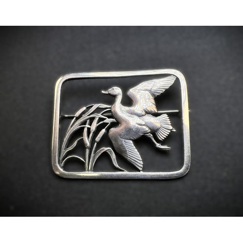 628A - GEORG JENSEN: a rounded rectangular silver brooch designed by Hugo Liisberg - a bird with outstretch... 
