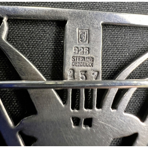 629 - GEORG JENSEN: a triangular silver brooch with dolphin diving through bullrushes, stamped to reverse ... 