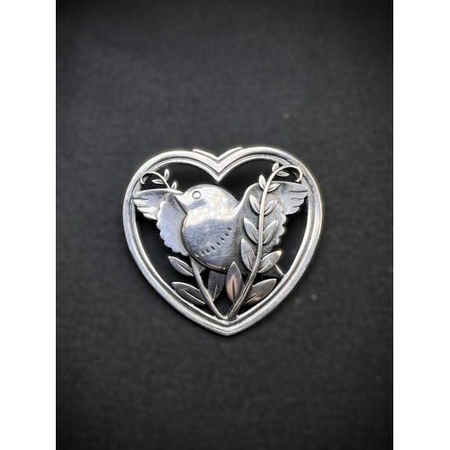 629D - GEORG JENSEN: a heart shaped silver brooch with bird in foliage, designed by Arno Malinowski, stampe... 
