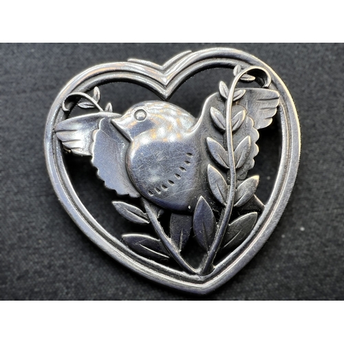 629D - GEORG JENSEN: a heart shaped silver brooch with bird in foliage, designed by Arno Malinowski, stampe... 