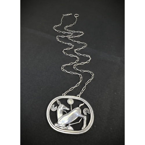 630B - GEORG JENSEN: an oval silver pendant of deer kneeling amongst stylised foliage, stamped to reverse G... 