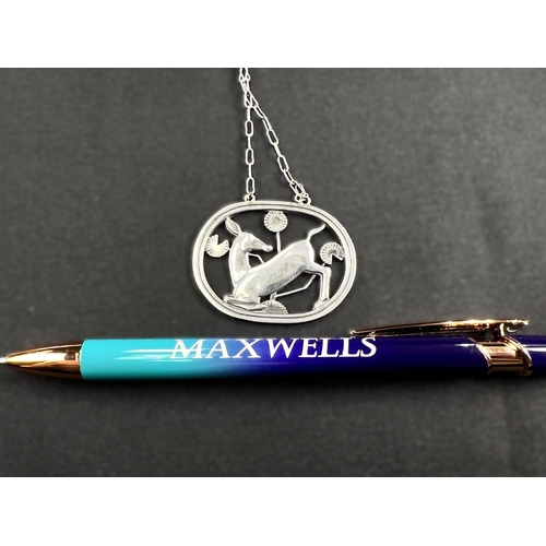 630B - GEORG JENSEN: an oval silver pendant of deer kneeling amongst stylised foliage, stamped to reverse G... 