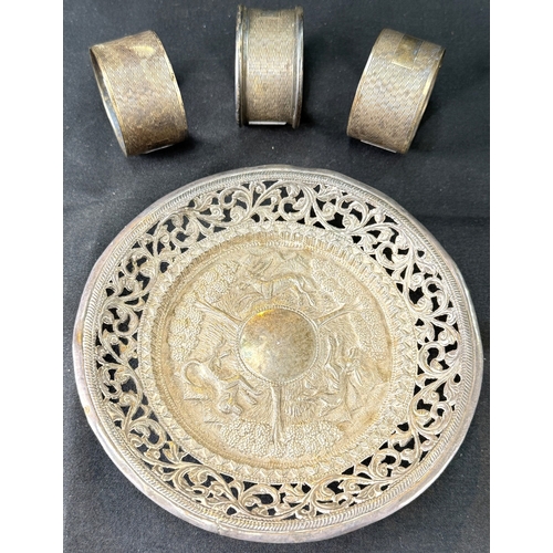 626 - A Far Eastern white metal shallow dish with extensive pierced relief decoration, on 4 ball feet, sta... 