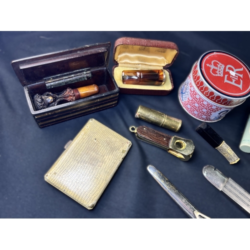 287 - A selection of cigar related items including amber and other holders, clippers etc.