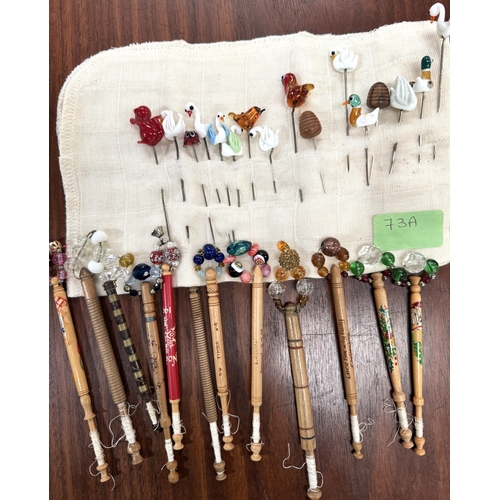 73A - A small collection of lace bobbins and glass hatpins