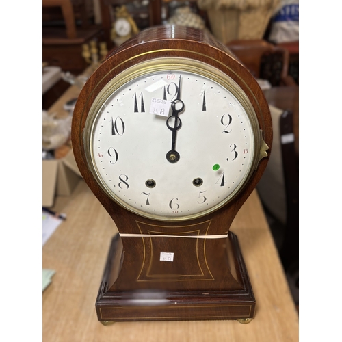 85A - An Edwardian inlaid mahogany balloon top mantel clock with white dial and striking movement